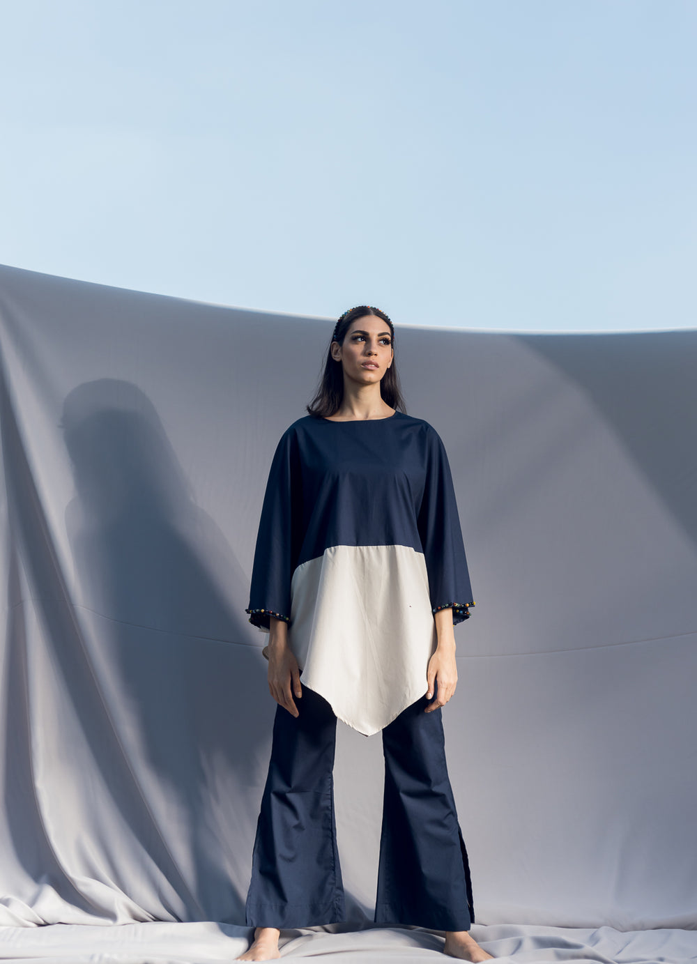 A lose fit round neckline blouse made of poplin cotton in navy blue and beige, detailed by hand embroidered multicolor precious stones.